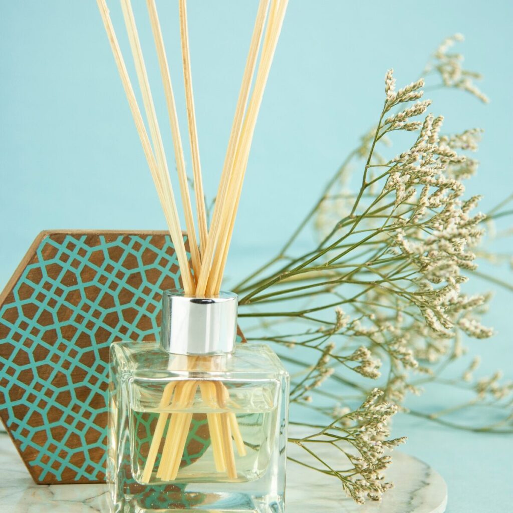 Scented candles and diffusers arranged on a summer-ready side table.