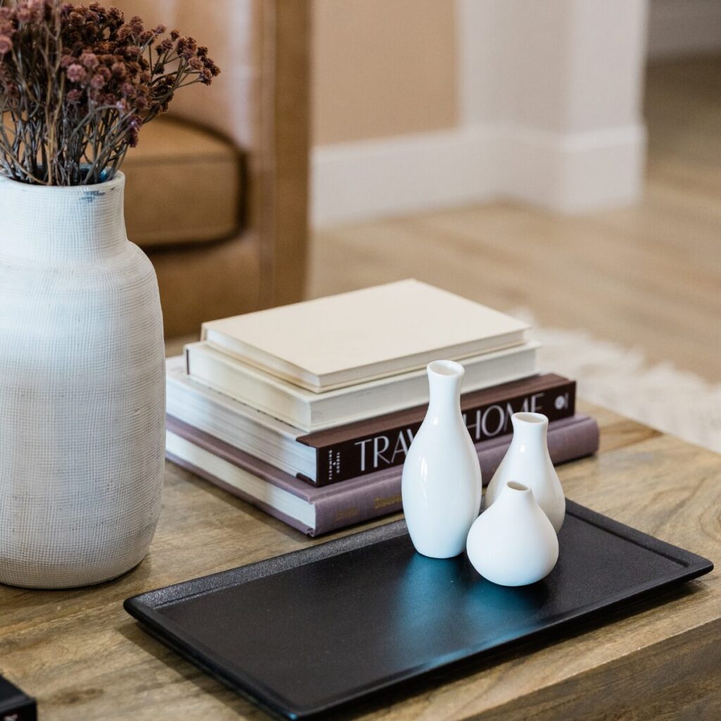 Coffee table display with books, candles, and a stylish round tray.