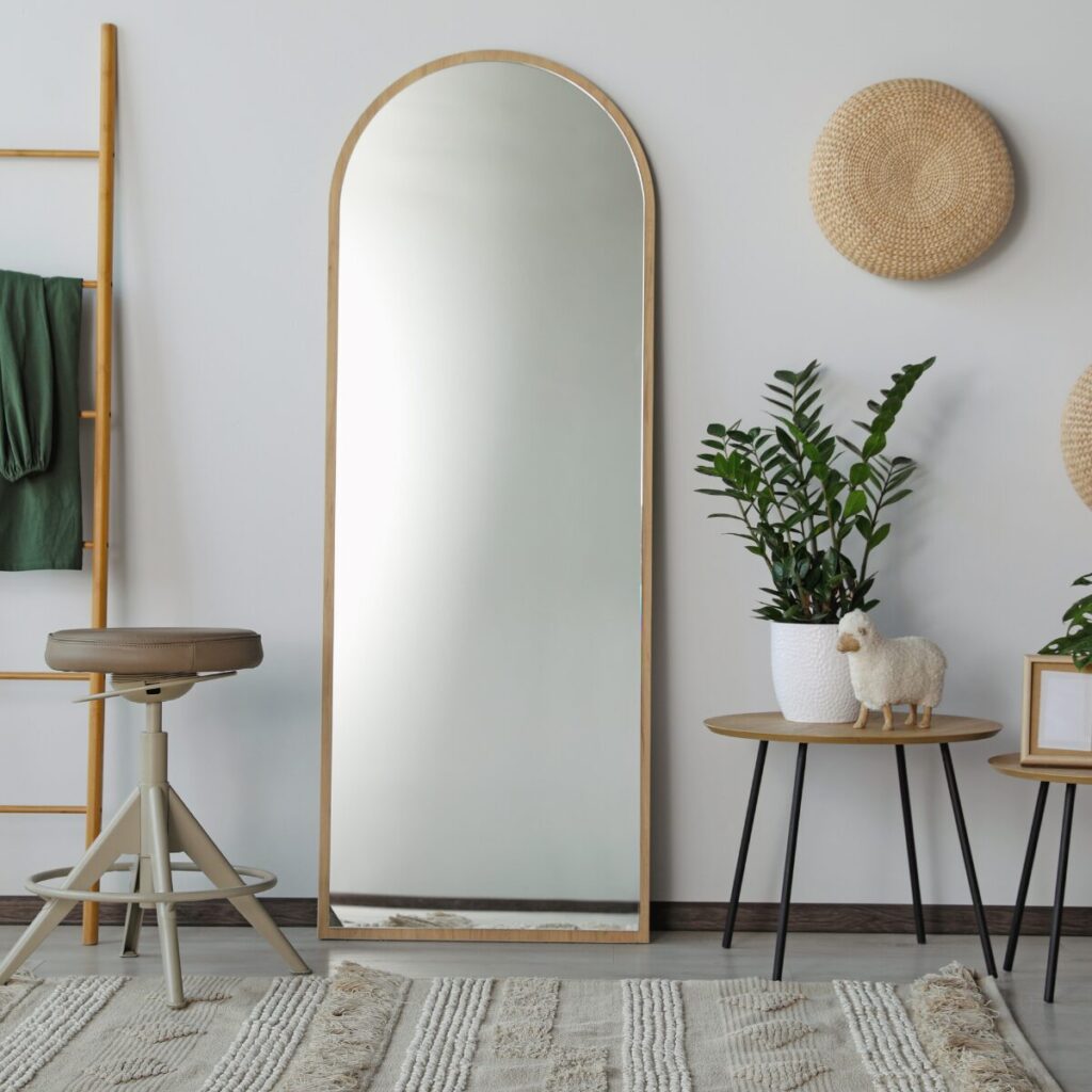 Light-reflecting round wall mirror styled above a console table.